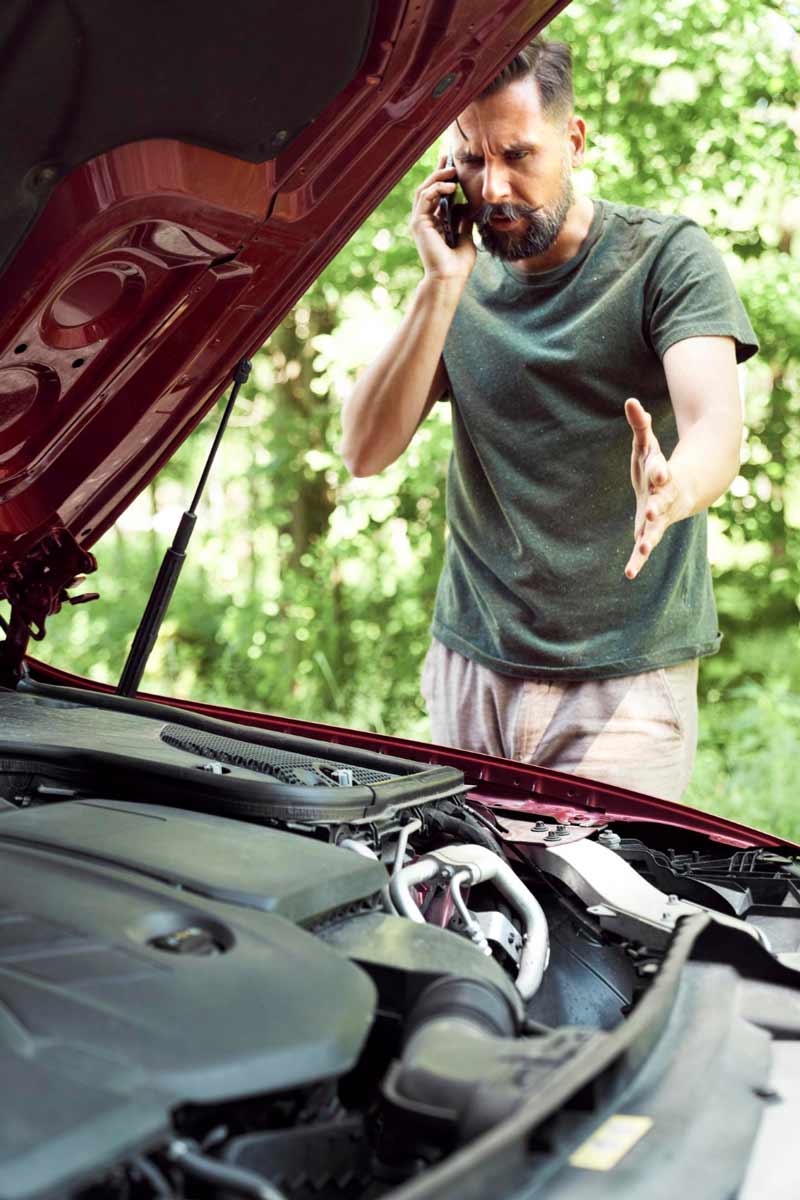 Junger Mann prüft Getriebeschaden bei Schrottauto Ankauf Bergisch Gladbach